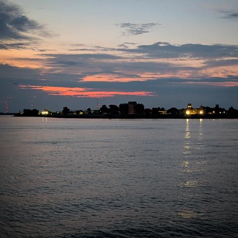 Twenty five minutes before sunrise the sky is turning orange over the West Bank of New Orleans and the Mississippi River. 