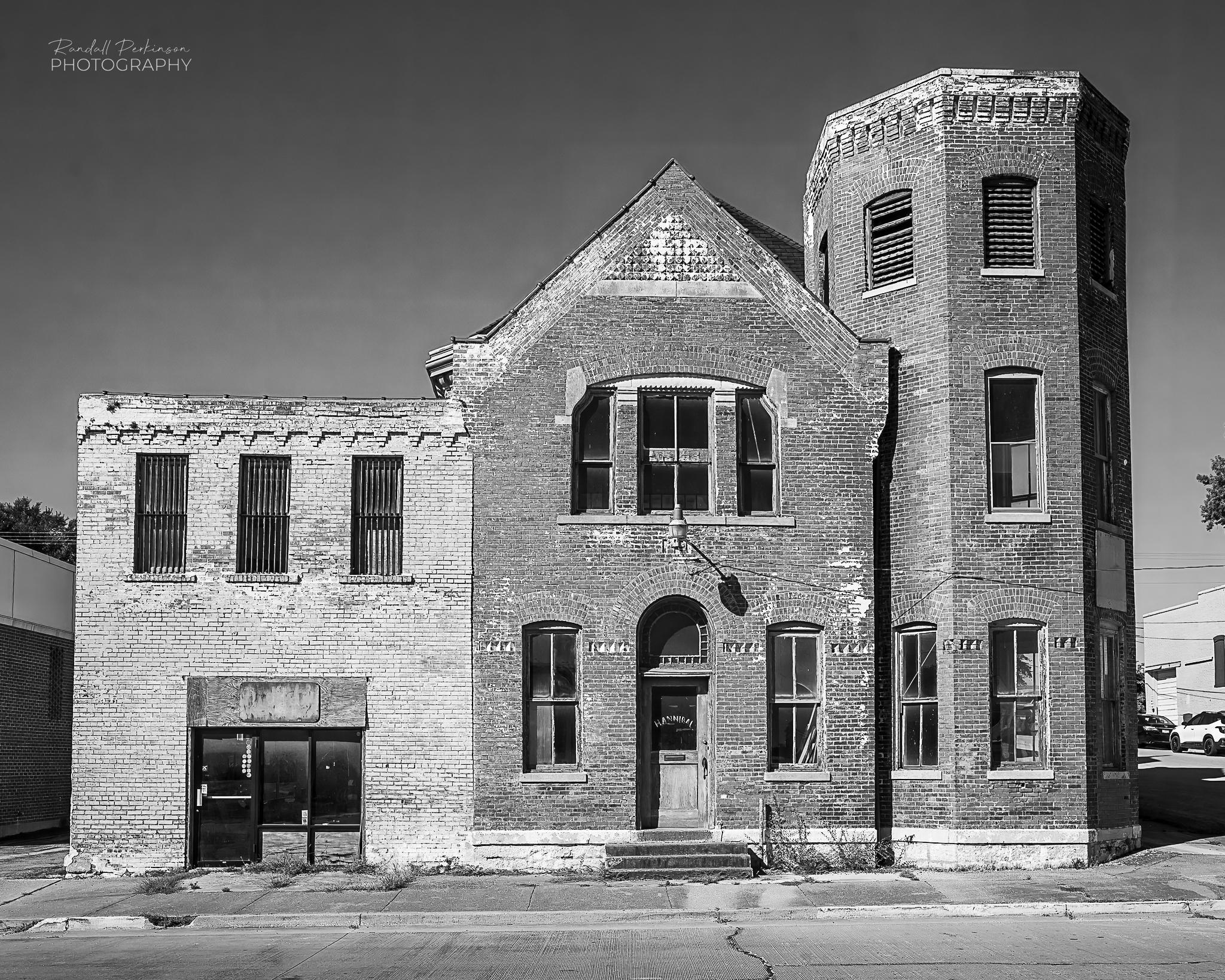 From Wikipedia, the free encyclopedia:

Hannibal Old Police Station and Jail
Built	1878-1879
Architects:  Hogg, John Oliver; Hogg, James Oliver
Architectural Style:  Late Victorian, High Victorian Eclectic
Added to NRHP	July 17, 1979

Hannibal Old Police Station and Jail, also known a City Hall, is a historic police station and jail located at Hannibal, Marion County, Missouri. It was built in 1878–1879, and is a two-story, eclectic late Victorian style brick building on a granite foundation. It features two octagonal towers of different heights and a complex roof defined by a heavy bracketed cornice.

It was added to the National Register of Historic Places in 1979. It is located in the Central Park Historic District.