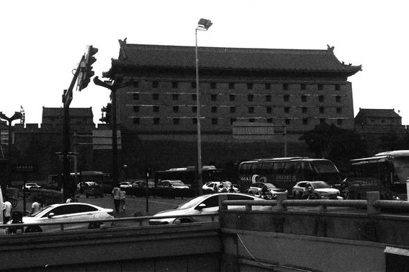 Lucky Lucky SHD 400 (FF)

English Alt Text:
A black-and-white photo shows a traditional Chinese building with ornate, tiered roofs in the background. In front, a busy street is filled with cars, buses, motorcycles, and pedestrians. Streetlights and traffic signals add to the urban atmosphere. The image contrasts heritage architecture with modern city life.

中文替代文字：
这是一张黑白照片，背景是一座具有多层飞檐的中国传统建筑。前方街道车流密集，包括汽车、公交车、摩托车和行人。街灯和交通信号灯增强了城市氛围。画面呈现传统建筑与现代生活的对比。