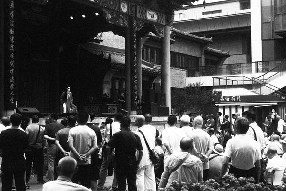 Lucky Lucky SHD 400 (FF)

English Alt Text:
A public performance unfolds on a traditional Chinese stage with ornate columns and a tiled roof. A performer stands mid-act, facing a crowd gathered in front. The audience is diverse, watching attentively. Behind the stage, modern buildings rise, contrasting with the classical architecture. The image captures cultural continuity in a contemporary urban setting.

中文替代文本：
一场公共表演在传统中式舞台上进行，舞台装饰精美，有雕花柱子和瓦片屋顶。一位表演者站在台上，面对前方聚集的观众。观众群体多样，专注观看。舞台背后是现代建筑，与古典结…