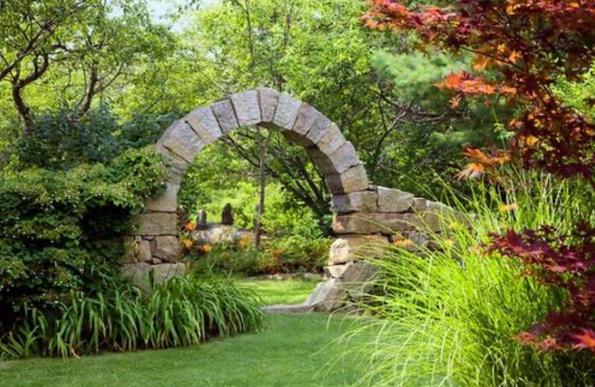 Image of a stone arch in a forest glade.