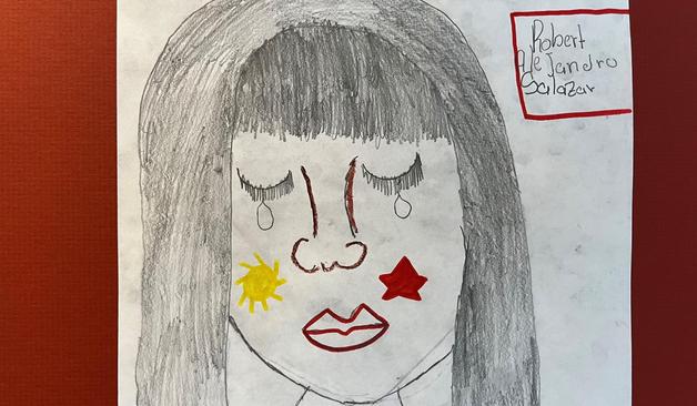 A child's drawing of a child's face, crying, with a sun and star on the cheeks. Name written as Robert Ale Jandro Salazar