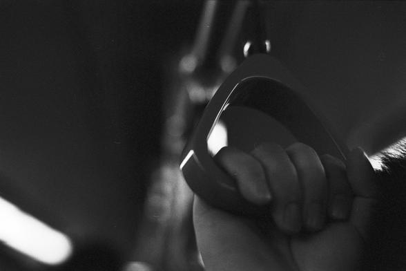 Lucky Lucky SHD 400 (FF)

English Alt Text:
A black-and-white close-up of a person’s hand gripping a triangular plastic handle suspended from above, commonly found in buses or trains. The hand is firm, suggesting motion or balance. The background is softly blurred, hinting at the interior of a public vehicle with indistinct lighting and shapes. The image captures a fleeting moment of urban commuting, emphasizing the tactile connection between human and infrastructure. The monochrome palette add…
