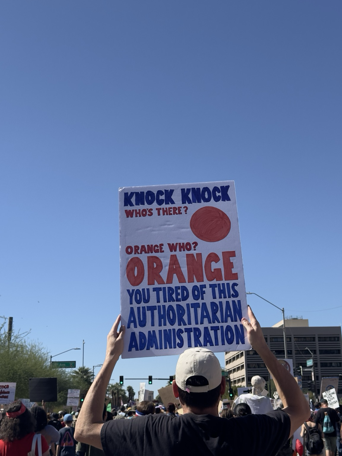 Sign that says “Knock Knock, who’s there? Orange. Orange who? Orange you tired of this authoritarian administration”