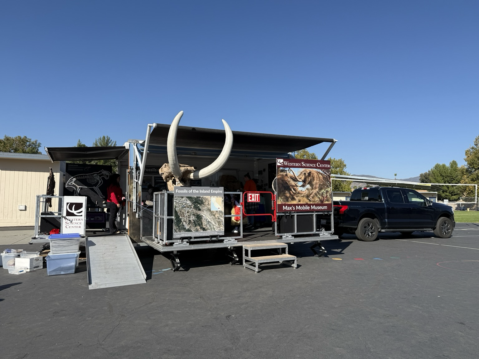 Mobile Museum trailer with mastodon skull and painting in front, and elementary school students inside.