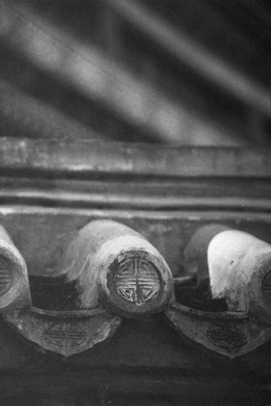 Ilford HP5 Plus 400 (FF)

English Alt Text: A monochrome close-up photograph of traditional Chinese roof tiles, focusing on the circular end caps. Each tile end is embossed with intricate patterns, possibly floral or symbolic motifs, representing cultural heritage. The tiles are arranged in a neat row, their textures highlighted by soft lighting. The image emphasizes craftsmanship and the tactile beauty of ancient architectural elements.

中文替代文字：
这是一张黑白特写照片，聚焦于中国传统屋顶瓦片的圆形瓦当。每个瓦当上都雕刻着精美图案，可能是花卉或…