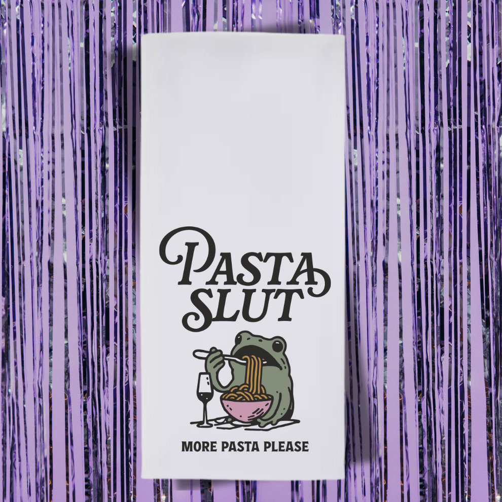 A towel with a frog wearing pasta. It says "Pasta Slut. More pasta please."