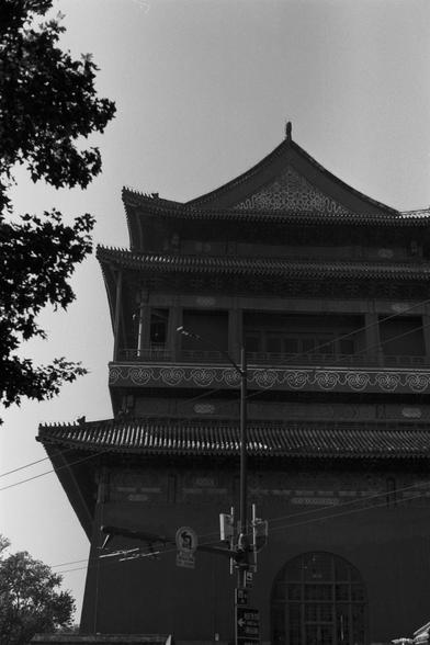 Ilford Pan 100 (FF)

English Alt Text: A black-and-white photo shows a multi-tiered traditional Chinese building, possibly a temple, with ornate upturned eaves and intricate facade details. The roof features carved embellishments typical of classical Chinese design. In the foreground, utility poles and street signs indicate a modern urban setting. Trees on the left side frame the building, emphasizing the contrast between ancient architecture and contemporary infrastructure.

中文替代文字： 这是一张黑白照片，画…