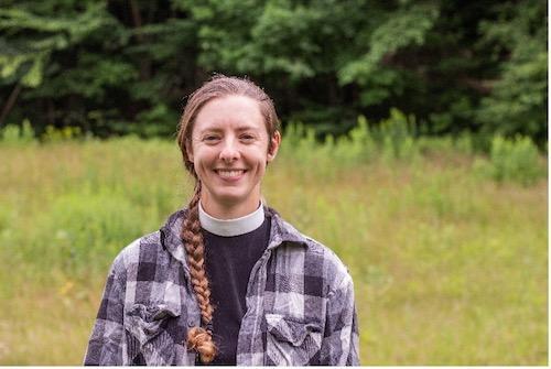 A woman outdoors in a clerical collar.