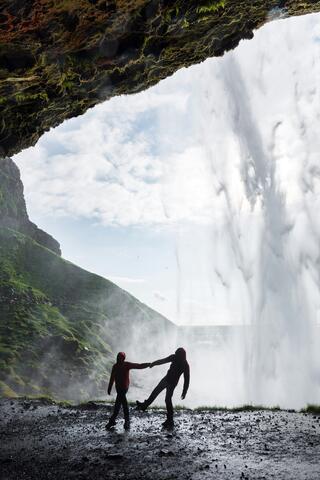 Two people in front of a waterfall