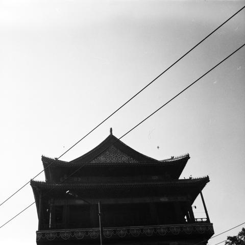 Lucky SHD 400 (6x6)

English Alt Text:
A striking black-and-white photo shows the silhouette of a traditional East Asian pagoda or temple. The structure features multiple tiers with upturned eaves and ornate roof decorations. Its dark outline contrasts sharply against a bright sky. Two diagonal power lines cross the image, adding a modern touch. Birds are seen flying in the sky, bringing motion to the stillness. The composition blends cultural heritage with contemporary elements, evoking a sens…