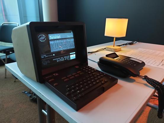 A beige and brown terminal from the 80s laying on a table, ready to be used