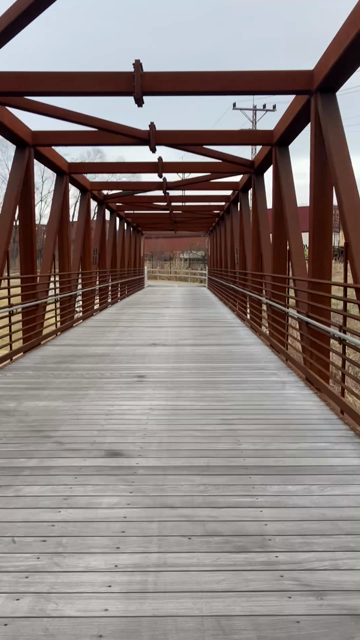 A massive freight train is pulling double decker cargo containers. The camera angle is first person POV as I’m running across a metal and wood pedestrian bridge over the Roanoke River. As I’m drawing to the end of the bridge, the path veers to the left to go parallel to the river, in between it and the tracks. 