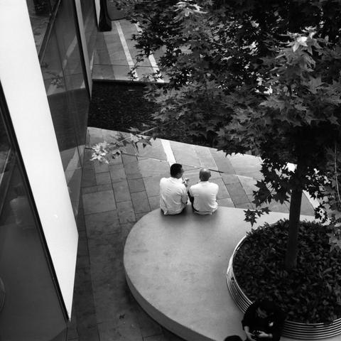 Lucky SHD 400 (6x6)

English Alt Text: A black-and-white overhead view of an urban plaza. Two people sit on a curved concrete bench surrounding a circular planter with a leafy tree. They appear to be talking or looking at something together. The ground is paved with rectangular tiles, and a glass building wall reflects part of the scene. Another person is partially visible near the planter. The image emphasizes quiet human interaction in a thoughtfully designed public space.

中文替代文本：
这是一张黑白俯视图，…