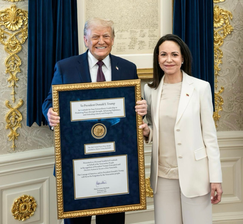 Grinning Trump with Nobel medal just received from Machado standing next to him.