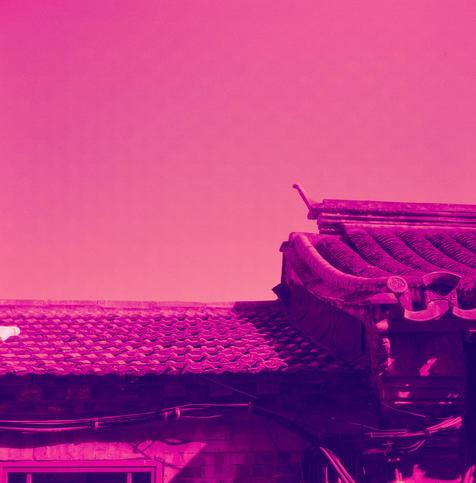 Harman Red 125 (6x6)

English Alt Text:
A close-up view of a traditional East Asian rooftop, likely Chinese, featuring ornate architectural details. The roof has curved eaves and upturned corners, with rows of dark tiles forming a rhythmic pattern. Decorative carvings adorn the edges, showcasing cultural craftsmanship. The image is heavily tinted with a magenta-pink filter, giving it a surreal, dreamlike quality. No sky or background is visible, focusing attention on the roof’s intricate design…