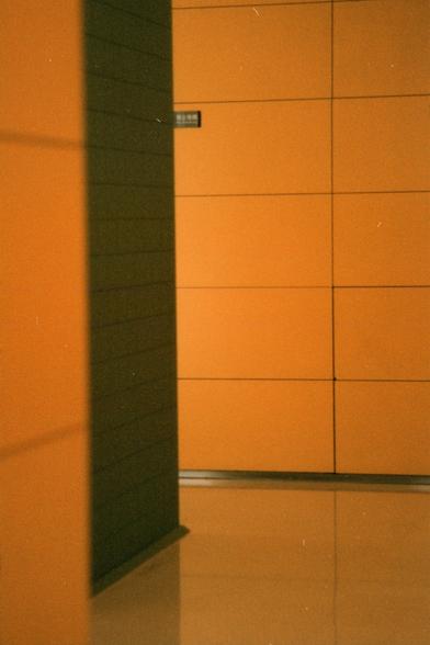 Harman Phoenix 200 II (FF)

English Alt Text:
An interior hallway features orange wall panels and a glossy floor that reflects the light and color. A dark vertical structure casts a shadow across the scene, creating contrast. In the background, a small sign with Chinese characters and the word “EXIT” is mounted on the wall, partially obscured by the shadow. The geometric design of the panels and interplay of light and shadow give the corridor a modern, architectural feel.

Chinese Alt Text:
室内走…