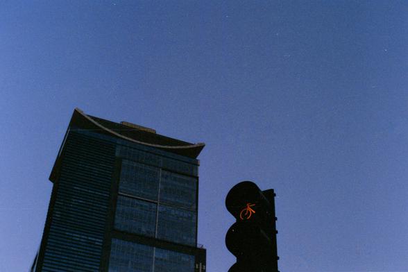 Harman Phoenix 200 II (FF)
English Alt Text:
A modern high-rise with a curved roof stands against a clear blue sky. In the foreground, a traffic light shows a red bicycle symbol, signaling cyclists to stop. The scene juxtaposes sleek architecture with transportation infrastructure, reflecting urban planning that balances design, safety, and mobility.

中文替代文字：
一座现代高层建筑在蓝天映衬下格外醒目，弧形屋顶勾勒出独特轮廓。前景中，交通信号灯亮起红色自行车标志，提示骑行者停下。画面展现建筑与交通设施的并置，体现城市规划对设计、安全与流动的平衡。