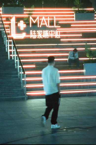 CineStill 800T (FF)

English Alt Text
A modern staircase lit by bright red horizontal light strips. At the top, a neon sign reads “MALL” along with Chinese characters. One person sits on the steps while another walks past in the foreground, slightly blurred from motion. The scene appears to be taken at night, emphasizing the vivid lighting.
Chinese Alt Text
现代楼梯上嵌有明亮的红色灯带。楼梯顶端有霓虹灯牌，写着“MALL”和中文字符。一人坐在台阶上，另一人从前景走过，因移动而略微模糊。夜间环境使灯光更加醒目。