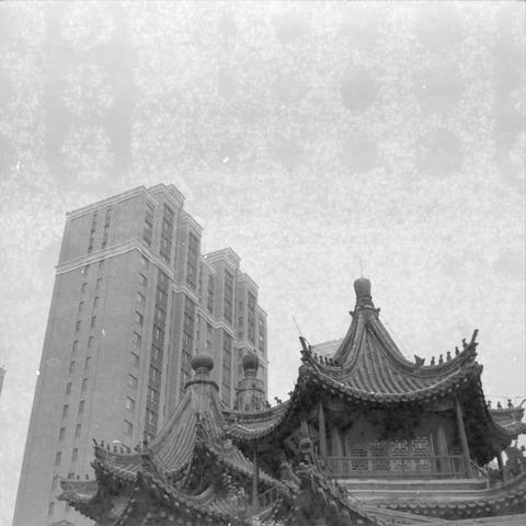 Ilford HP5 Plus 400 (6x6)

Alt Text (English)
A color image showing a traditional East Asian building in the foreground with ornate curved roofs and detailed decorative ridges. Behind it rises a tall modern high‑rise with a simple geometric design. The contrast highlights old and new architectural styles coexisting in the same urban space.

Alt Text (Chinese)
一张彩色照片，前景是一座东亚传统建筑，屋顶弯曲精致，装饰细节丰富。背景是一栋现代高层建筑，线条简洁、几何感强。画面呈现传统与现代建筑在城市中并存的对比。