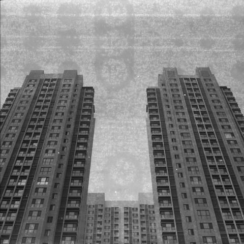 Ilford HP5 Plus 400 (6x6)

Alt Text (English)
A black‑and‑white photo taken from a low angle, showing three tall residential buildings. Two stand in the foreground like symmetrical towers, while a third rises between them in the distance. The buildings have many windows and balconies. The sky is hazy, and the image includes grainy, textured effects.

Alt Text (Chinese)
一张黑白照片，从低角度拍摄三栋高层住宅楼。前方两栋对称耸立，后方一栋位于中间更远处。建筑上布满窗户和阳台。天空灰白，画面带有颗粒和旧胶片般的纹理。