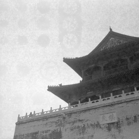 Ilford HP5 Plus 400 (6x6)

English Alt Text
A black‑and‑white image of a traditional Chinese bell tower. The structure features layered, upturned eaves and intricate wooden carvings. It stands on a stone platform with a decorative railing. A plaque on the stone wall bears Chinese characters meaning “Bell Tower.”
中文替代文字
一张黑白照片，呈现一座传统中国钟楼。建筑有多层飞檐和精致木雕，立于石基之上，周围有装饰性栏杆。石墙上的牌匾写着“钟楼”二字。
