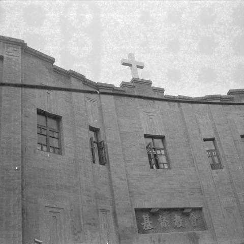 Ilford HP5 Plus 400 (6x6)

English alt text:
A black‑and‑white photograph of a brick church building. A cross stands at the top of the curved roofline. The facade has rectangular windows, some open, and a decorative cornice. A stone plaque with Chinese characters identifying it as a Christian church is mounted below the windows.
中文替代文字：
一张黑白照片，画面是一座砖结构的教堂。屋顶弧形边缘上立着一个十字架。外墙上有数个矩形窗户，其中一些是打开的。窗下嵌有刻着中文“基督教会”的石碑。