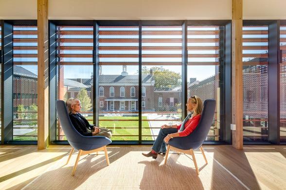 Two people sitting in front of lovely glass windows with little dots that help birds avoid crashing into them.
