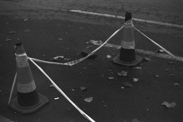 Ilford FP4 Plus 125 (FF)

English alt text

A black‑and‑white photo of two traffic cones placed on a paved street. A strip of caution tape stretches between them. The cone on the right has a damaged top. Dry leaves are scattered across the ground. The scene appears quiet, with no people or vehicles visible.

中文替代文字

一张黑白照片，画面中有两个放在路面上的交通锥，中间拉着一条警示带。右侧的交通锥顶部破损。地面上散落着一些干叶。画面中没有行人或车辆。