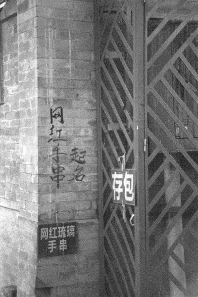 Ilford FP4 Plus 125 (FF)
English:

This is a black-and-white photograph of a building exterior. On the left side, there is a vertical sign with Chinese characters written on the wall. Below the sign, there is another rectangular sign with Chinese text. To the right, there is a metal gate with diagonal bars, and a smaller sign with the Chinese character "包" is attached to the gate.
普通话:

这是一张黑白照片，拍摄的是一栋建筑的外墙。左边墙上有一个竖排的汉字标志。标志下方还有一个矩形的汉字标牌。右边是一个带有对角金属条的金属门，门上附有一个写着“包”字的小标牌。