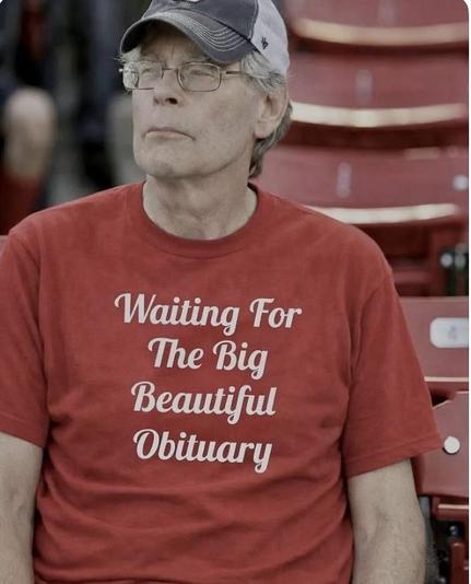 Image of an elderly white man wearing a red shortsleeved t-shirt with text reading, Waiting for the Big Beautiful Obituary.