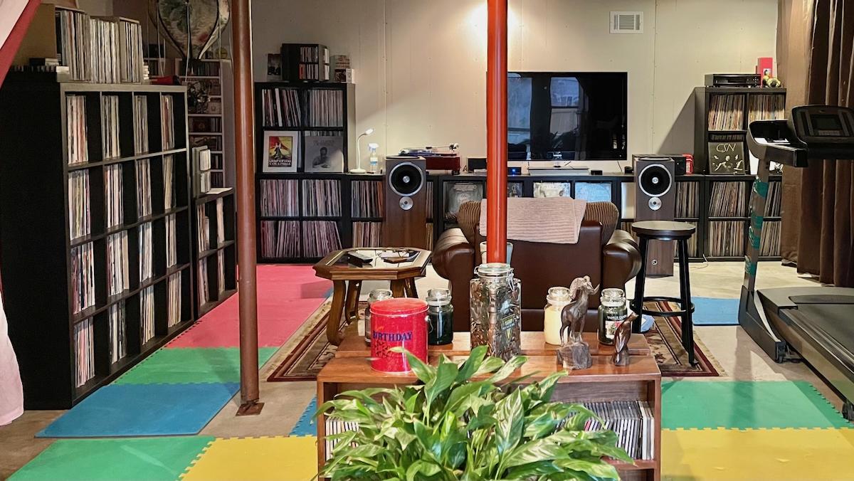 a 450 square foot room with shelves full of record albums against two walls.