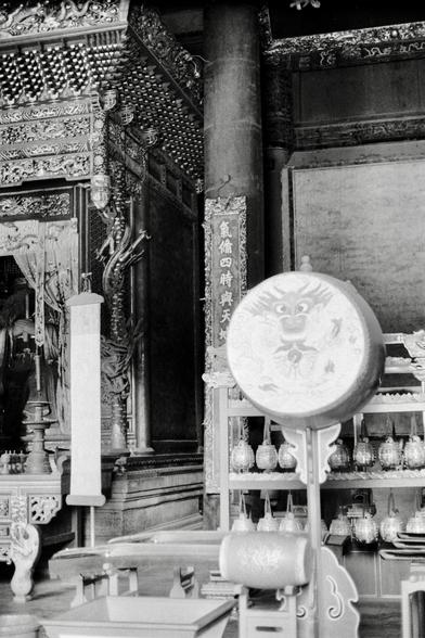 Lucky LUCKY SHD 400 (FF)

##English

A black-and-white photograph of an ornate temple interior. The foreground features a large drum with a dragon face carved on it, mounted on a stand. To the left, there is a vertical banner with Chinese characters. Behind the drum, shelves hold several small bell-like objects. The background shows intricate wooden carvings and decorations, including a large altar with statues and offerings. The architecture is traditional, with detailed patterns and motifs.

…