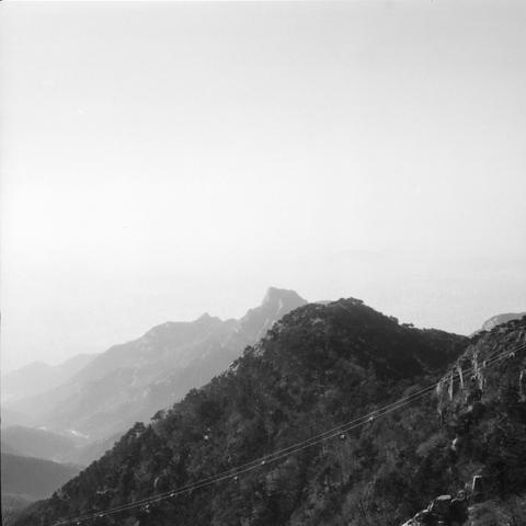 Lucky LUCKY SHD 400 (6x6)

English

A black-and-white photograph of a mountainous landscape. The foreground features a steep, forested hillside with a cable or wire running diagonally across the scene. The background shows a range of distant mountains, partially obscured by mist or clouds.

中文

一张黑白照片，展示的是山区风光。前景是一个陡峭的、林木茂盛的山坡，一条电缆或金属线斜穿过画面。背景是一系列遥远的山脉，部分被雾或云遮挡。