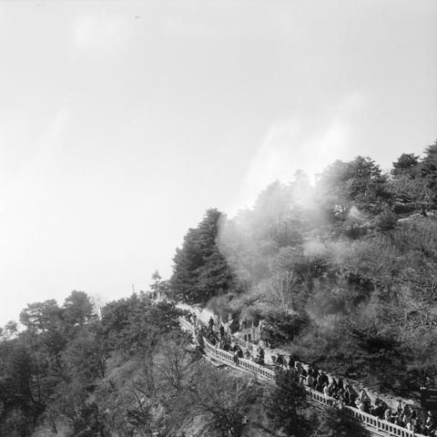 Lucky LUCKY SHD 400 (6x6)

English

A black-and-white photograph showing a long, winding staircase ascending a forested hillside. Many people are walking up the staircase, which is flanked by trees and shrubs. The sky above is bright, and the trees create a misty, atmospheric effect.

中文

一张黑白照片，展示了一条长长的、蜿蜒的楼梯沿着林木茂盛的山坡向上延伸。许多人正在攀登这条楼梯，楼梯两侧是树木和灌木。天空明亮，树木形成了一种雾蒙蒙的、富有氛围的效果。