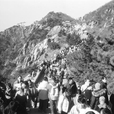 Lucky LUCKY SHD 400 (6x6)

English

A black-and-white photograph captures a wide, upward-sloping path leading to a mountain peak. The path is crowded with people walking in both directions. The mountain is rocky with patches of vegetation. At the top, there is a structure that appears to be a pavilion or temple. The scene suggests a popular hiking or pilgrimage site.

中文

这张黑白照片拍摄了一条宽阔的上坡小路，通向一座山峰。小路上挤满了来往行人。山体多岩石，间杂着植被。山顶有一座类似亭子或庙宇的建筑。场景表明这是一个热门的徒步或朝圣地点。