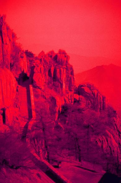 Harman Red 125 (FF)

English

A striking red-toned image of a rocky mountain landscape. The rugged cliffs and rocky outcrops dominate the scene, with a narrow staircase carved into the rock, leading upward. The sky is a deep red, creating a dramatic contrast with the dark shadows of the rocks. The overall effect is intense and evocative, emphasizing the natural grandeur of the landscape.

中文

一幅以红色调为主的岩石山景照片。崎岖的悬崖和岩石突出物主导了整个画面，岩石上凿出了一条狭窄的楼梯向上延伸。天空呈深红色，与岩石的阴影形成强烈对比。整体效果强烈而富有感染力，突显了自然景观的壮丽。