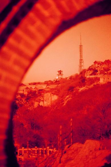 Harman Red 125 (FF)

English

A sepia-toned photograph showing a scenic view through an archway. In the distance, there is a hill with a pagoda-style building and a tall radio or observation tower. The foreground features trees and some structures, creating a layered, vintage landscape.

中文

一张带有棕褐色调的照片，通过拱门展示了一个风景优美的景观。远处是一个小山丘，上面有一座亭台楼阁式的建筑和一座高耸的无线电或观景塔。前景有树木和一些建筑，构成了一个层次分明的复古风景。