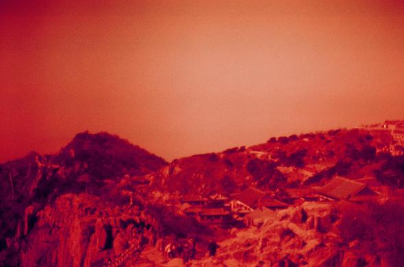 Harman Red 125 (FF)

##English

A red-tinted landscape photograph of a mountainous area with buildings scattered across the hills. The sky is a gradient of red and orange, creating a dramatic and intense atmosphere. The buildings appear to be nestled within the mountainous terrain, blending with the natural surroundings.

##中文

一张带红色调的山区风景照片，山坡上散布着一些建筑物。天空呈红橙色渐变，营造出戏剧性和强烈的氛围。建筑物融入山区地形，与自然环境相互映衬。