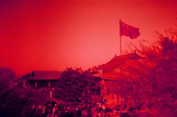 Harman Red 125 (FF)

##English

A red-tinted photograph of a traditional Chinese building with a red flag flying on a flagpole. The building has a classic curved roof and is surrounded by trees. A crowd of people is gathered in front of the building, suggesting a public or ceremonial event. The sky is red, adding a dramatic effect to the scene.

##中文

一张带红色调的照片，展示了一座传统中国建筑，建筑上方有一面红旗在旗杆上飘扬。建筑物具有经典的弯曲屋顶，周围环绕着树木。建筑前聚集了一群人，暗示可能是公共活动或仪式。天空呈红色，为场景增添了戏剧性效果。