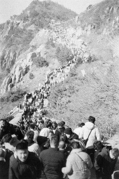 Lucky LUCKY SHD 400 (FF)

English:

A black-and-white photograph of a steep, mountainous path crowded with people ascending. The path is flanked by rocky cliffs and sparse trees. The crowd stretches far up the path, indicating a popular hiking or pilgrimage route. The scene suggests a busy, possibly historic or scenic location.

中文：

一张黑白照片，展示了一条陡峭的山路，许多人正在攀登。道路两旁是岩石峭壁和稀疏的树木。人群沿着山路延伸很远，表明这是一个热门的徒步或朝圣路线。场景显示这是一个繁忙的、可能具有历史意义或风景优美的地点。