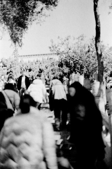 Lucky LUCKY SHD 400 (FF)

English

A black-and-white photo of a crowded outdoor scene. Many people are walking or standing, some partially blurred due to motion. The background shows trees and possibly a fence or structure, suggesting a park or public space.

中文

一张黑白照片，展示了户外拥挤的场景。许多人在行走或站立，部分人因动作而模糊。背景有树木和可能是围栏或建筑物，暗示这是一个公园或公共场所。