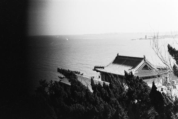 Lucky LUCKY SHD 400 (FF)

English

A black-and-white landscape photograph featuring a traditional Asian-style building with a tiled roof, located near a body of water. The building is partially obscured by trees in the foreground. The water is calm, and the horizon is visible in the background.

中文

一张黑白风景照，展示了一座传统亚洲风格的瓦屋顶建筑，位于水边。建筑物部分被前景的树木遮挡。水面平静，远处的地平线清晰可见。