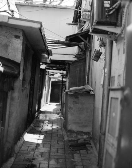 Lucky LUCKY SHD 400 (6x7)

English

A narrow, dimly lit alleyway in an urban setting. The alley is flanked by old, weathered buildings with visible wear and peeling paint. Overhead, a network of electrical wires and makeshift awnings can be seen. The ground is paved with bricks, some of which appear damp or stained. The alley extends into the distance, creating a sense of depth and leading the eye toward a brighter area at the end.

中文

一个狭窄、光线昏暗的城市小巷。巷子两侧是老旧、风化的建筑，墙面有明显的磨损和剥落的油漆。头顶上方有电线和临时搭建的遮…