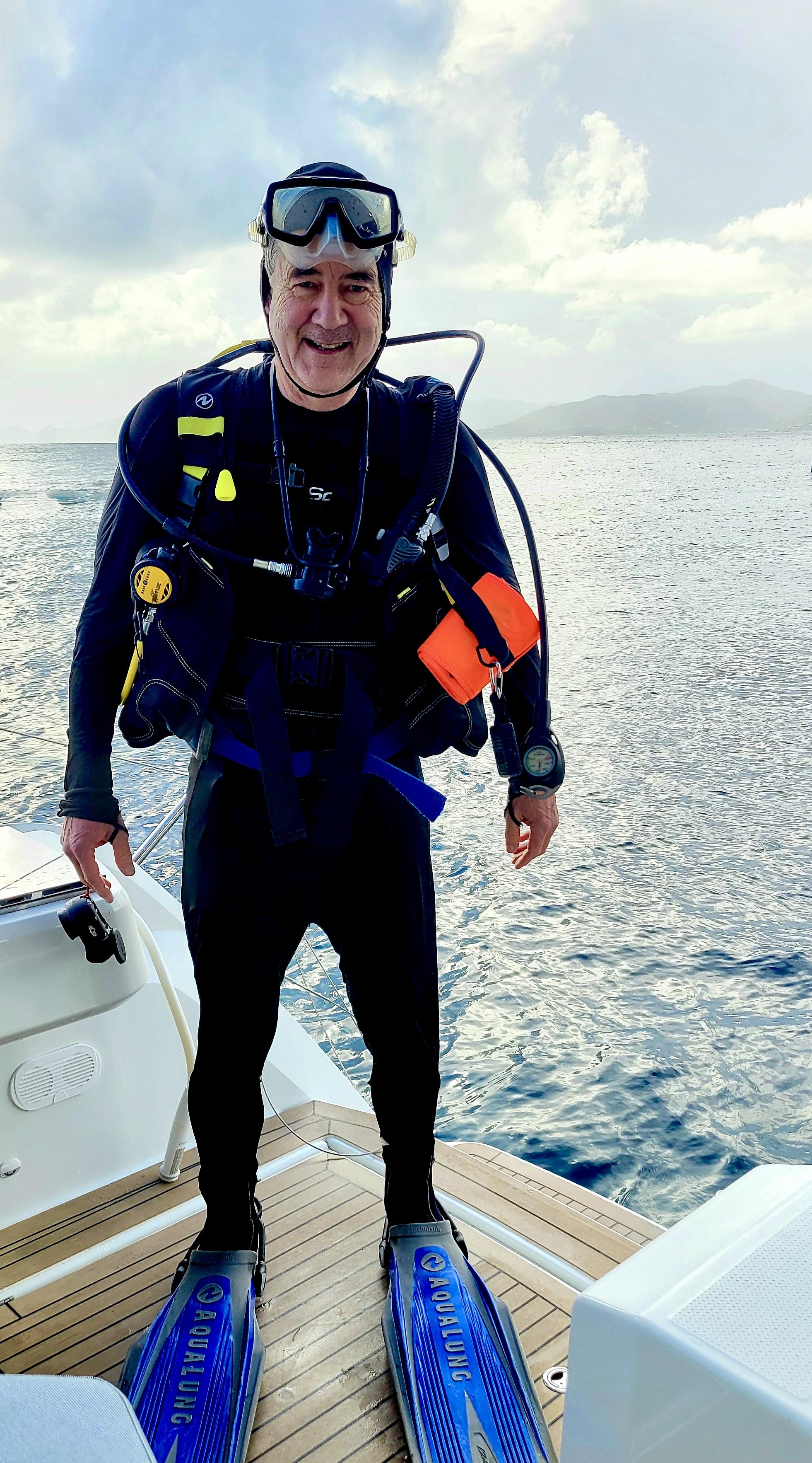 Photo of me wearing my scuba gear as I am just about to dive into the water from the sailboat.  My mask is up on my forehead and my regulator is off of my mouth for this posed photo.  I look happy as I am just about to go on my first dive of the trip.

Machioneel Bay, Cooper Island.