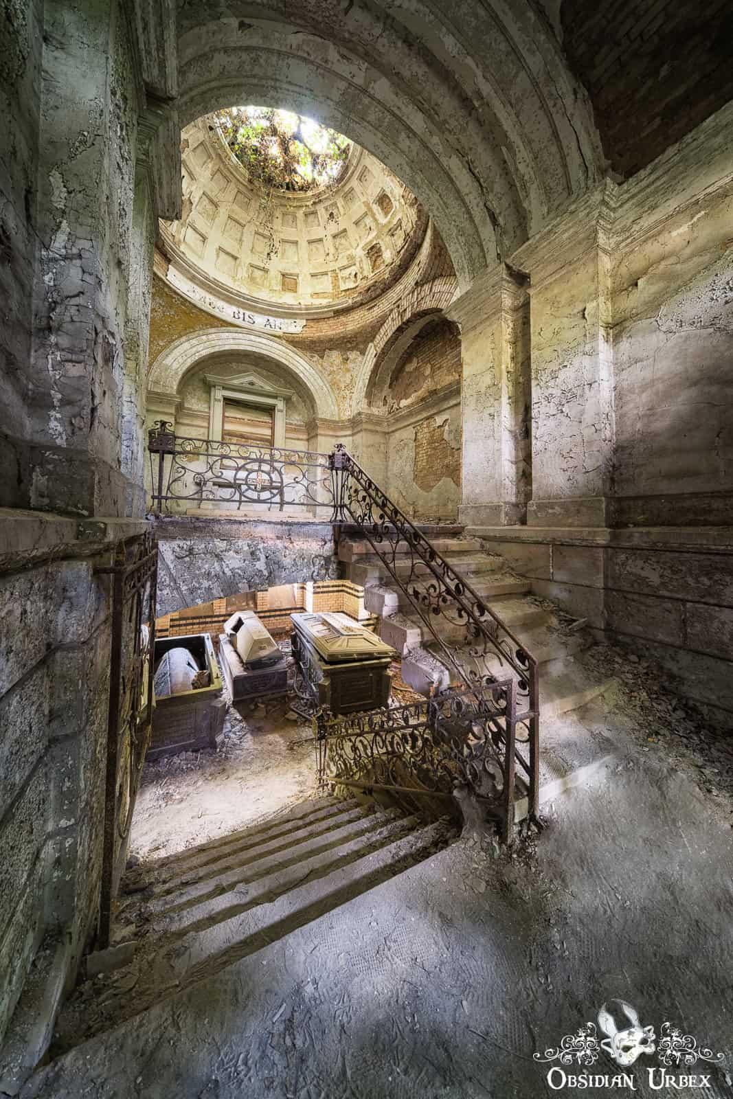 A striking Neoclassical rotunda mausoleum, with a domed oculus letting light into the decaying interior. Ornate stairs descend to coffins in the undercroft.