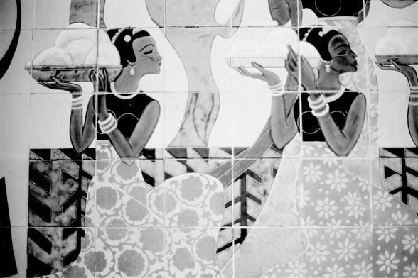 ERA 100 (FF)

English
Black-and-white mosaic of two stylized women in long dresses with floral patterns. Both have short hair, wear bracelets, and hold circular objects. The background features geometric and abstract shapes.
中文
黑白马赛克图，描绘两名穿着带花纹长裙的女性。她们都留着短发，戴着手镯，手持圆形物体。背景由几何和抽象图案组成。