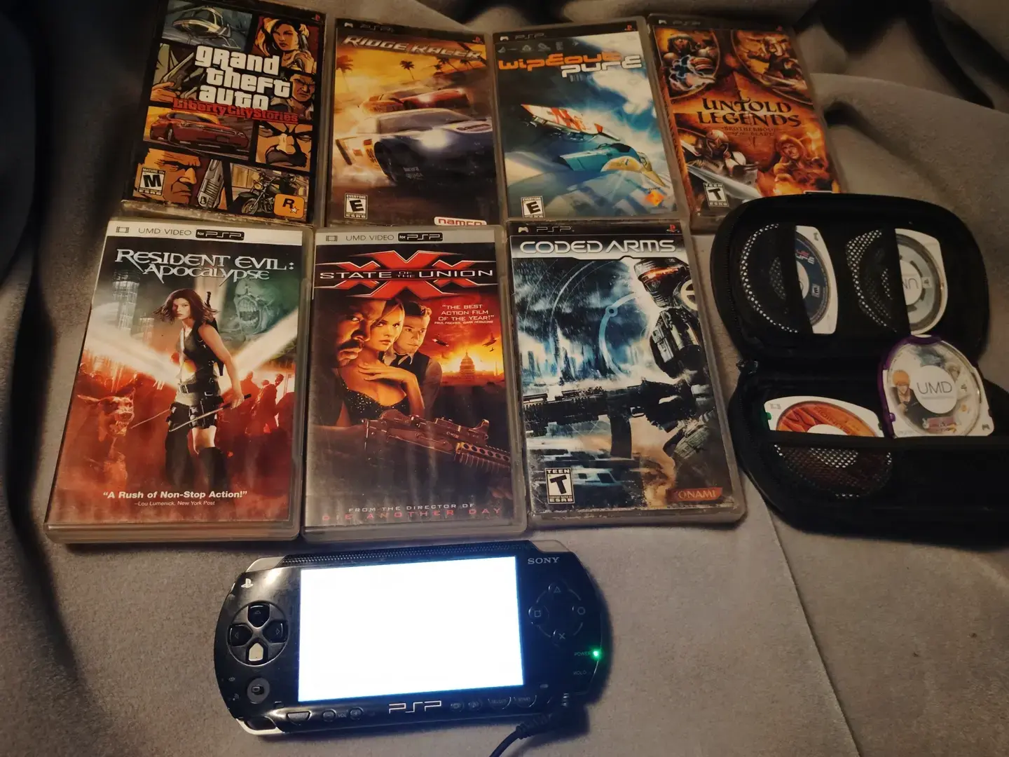 Sony PSP-1000 with a bunch of various games. Grand theft Auto liberty city stories, ridge racer, wipe out pure, untold legends, coded arms, bleach heat the soul 3 & a couple of movies: resident evil apocalypse & xXx state of the union.