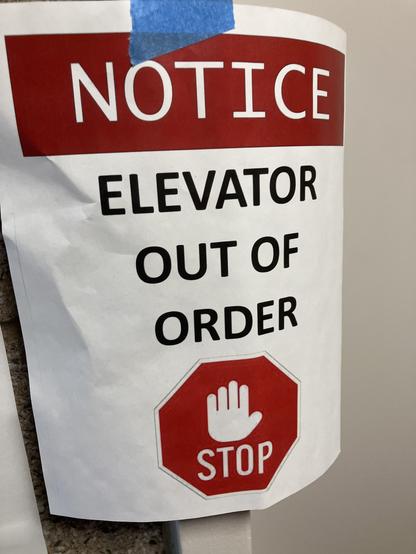 A notice posted on a wall indicating that the elevator is out of order, featuring a stop sign graphic.