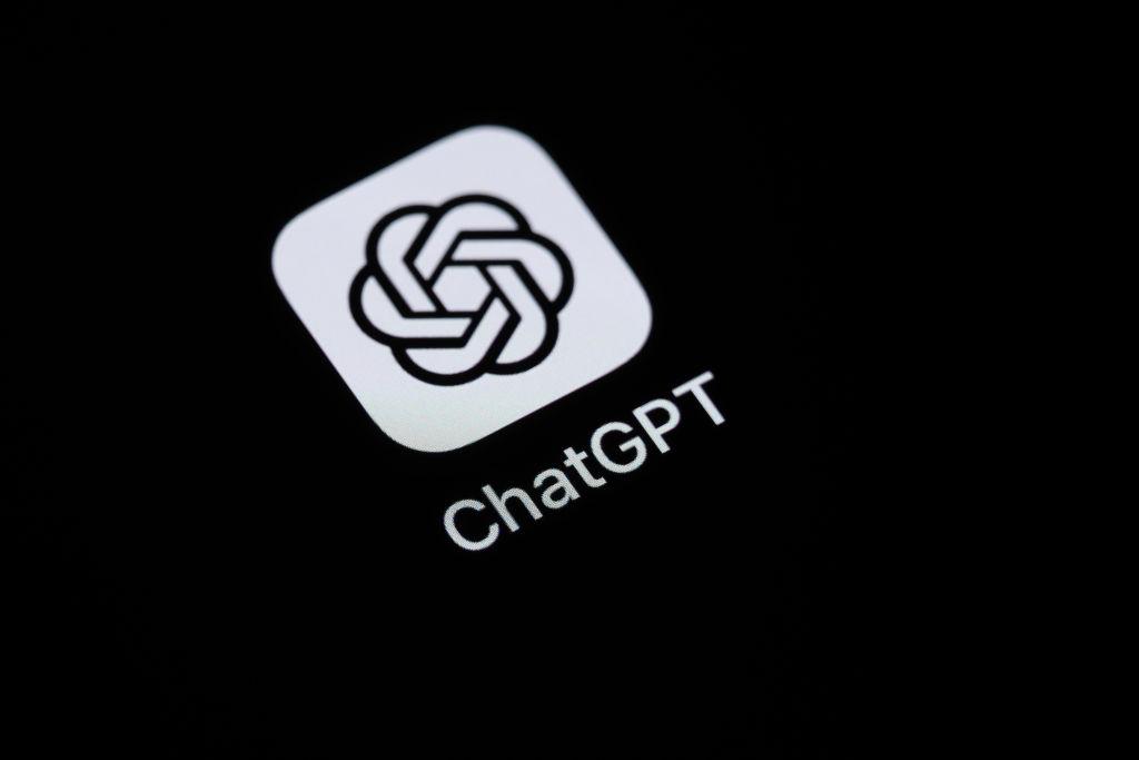 the chatgpt logo. three black  intertwined shackles on a white square background with rounded corners. underneath is written chatgpt in white on a black background.